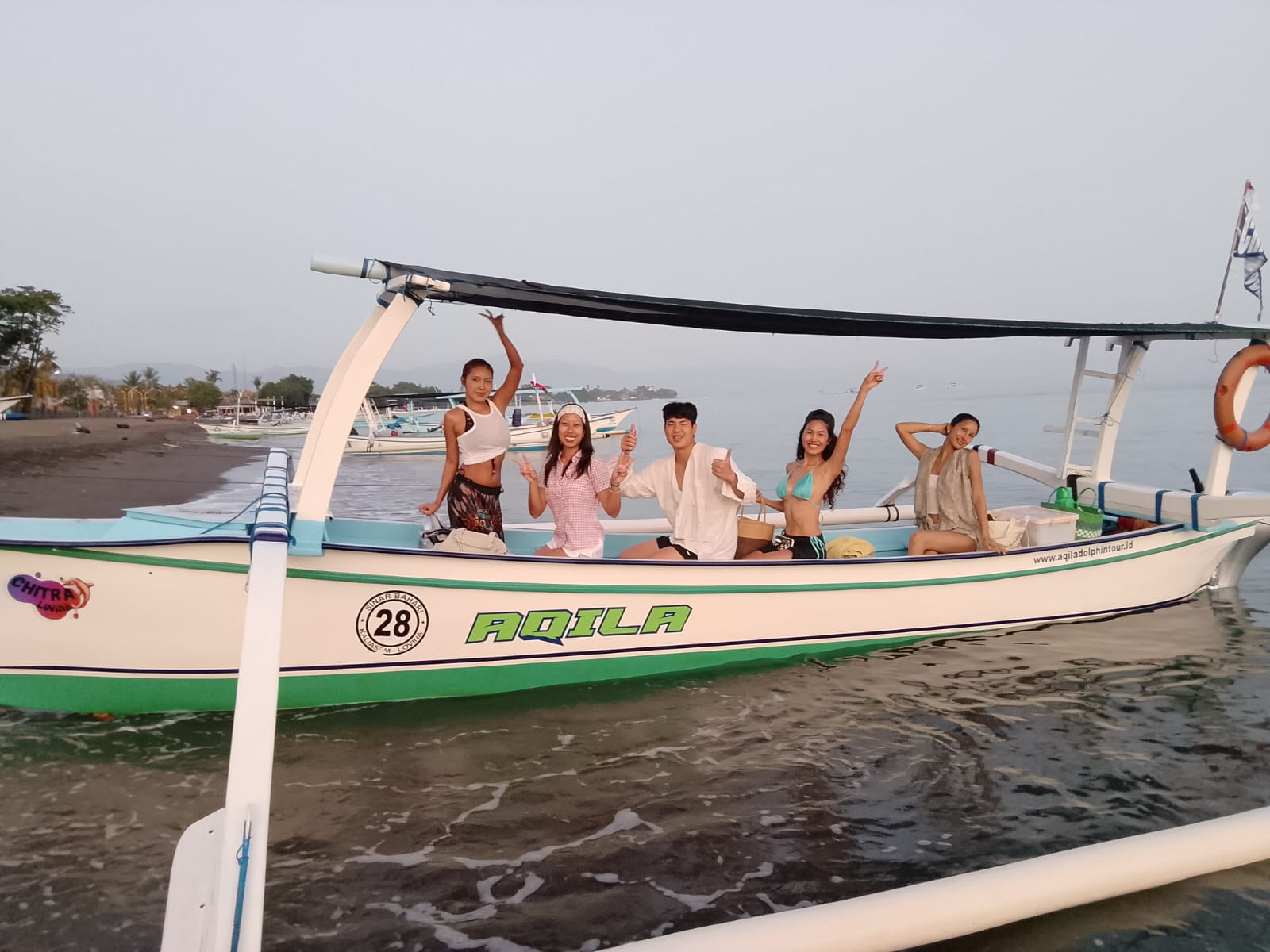 Group of guests posing on the traditional outrigger boat at the Lovina shoreline